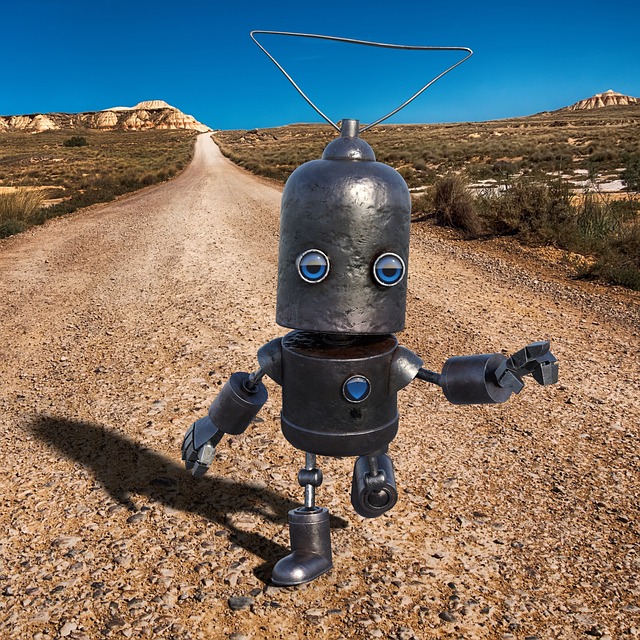Robot på grusväg i ökenlandskap under klarblå himmel.